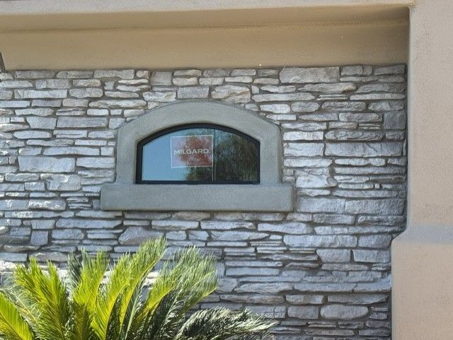 Stone veneer detail around an arched window